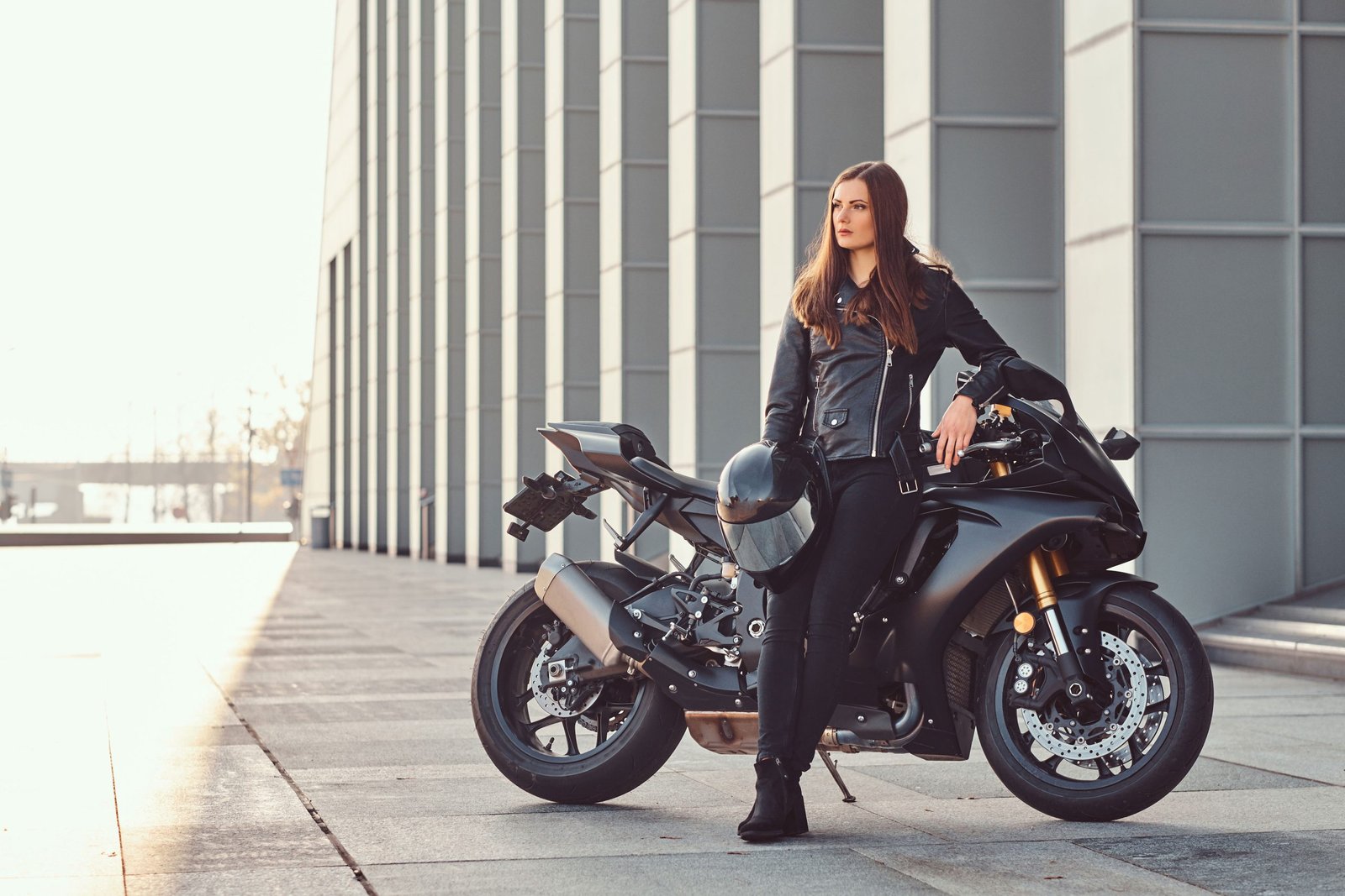 beautiful-biker-girl-wearing-black-leather-jacket-leaning-her-superbike-outside-building-sunny-day